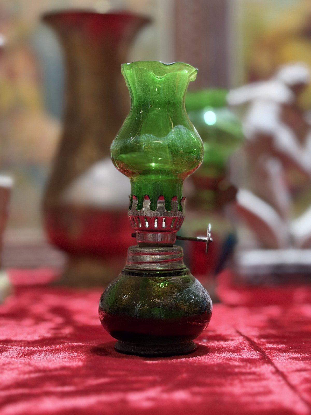 Miniature oil lamp in green glass with a metal burner
