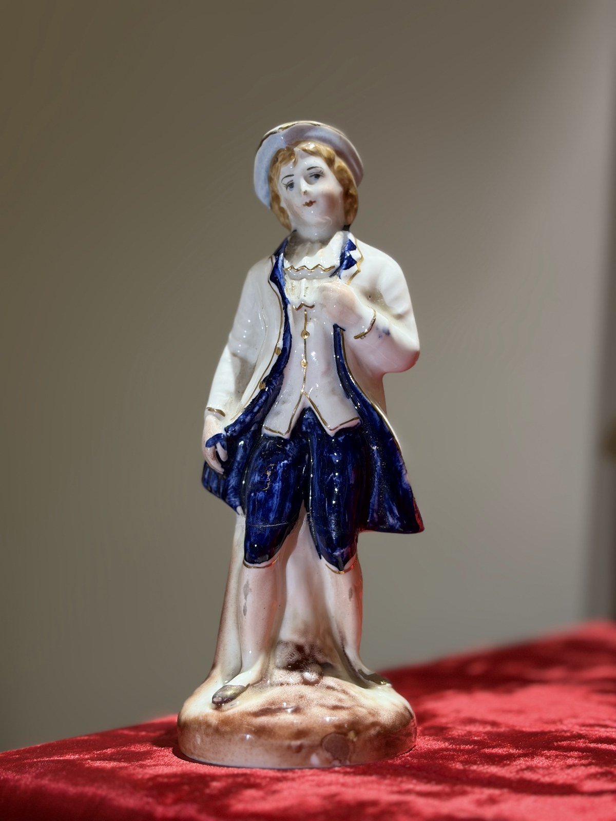 Glazed porcelain figurine of a gentleman in a cobalt blue coat